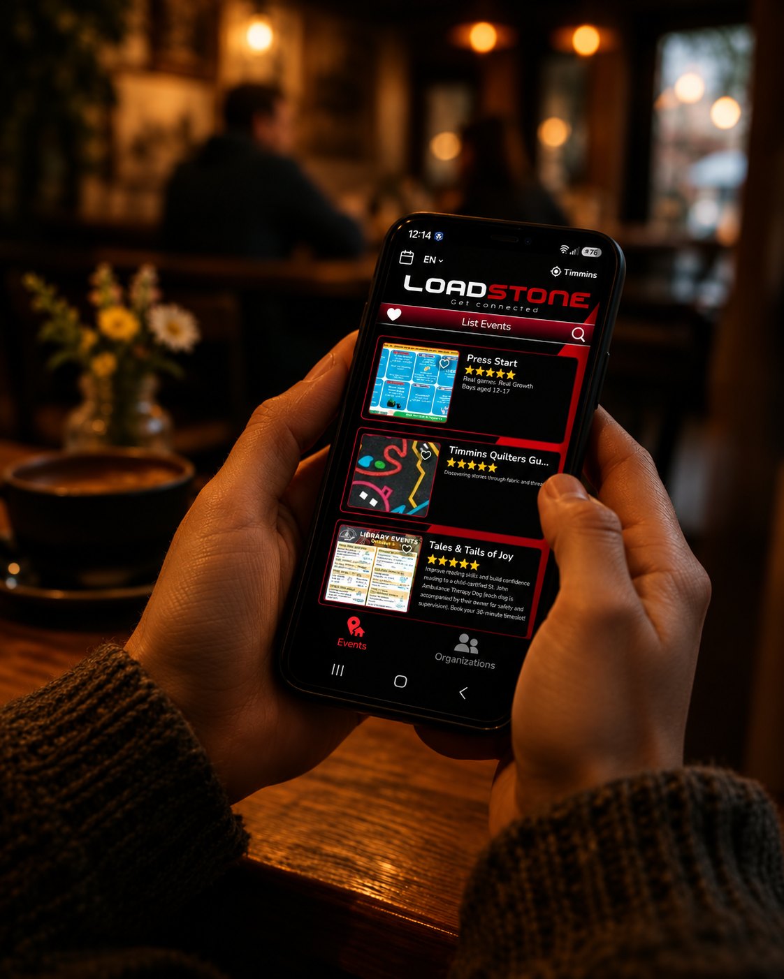Hands holding a phone displaying the Loadstone Timmins community app